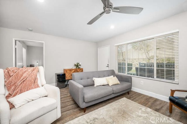 living area with ceiling fan, wood finished floors, and baseboards