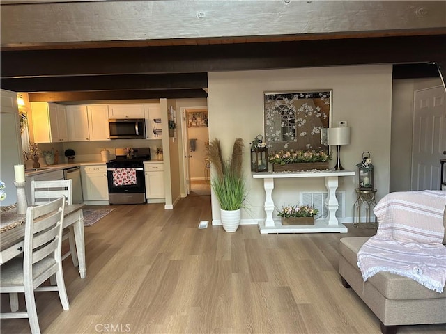 living room with sink, light hardwood / wood-style floors, and beamed ceiling