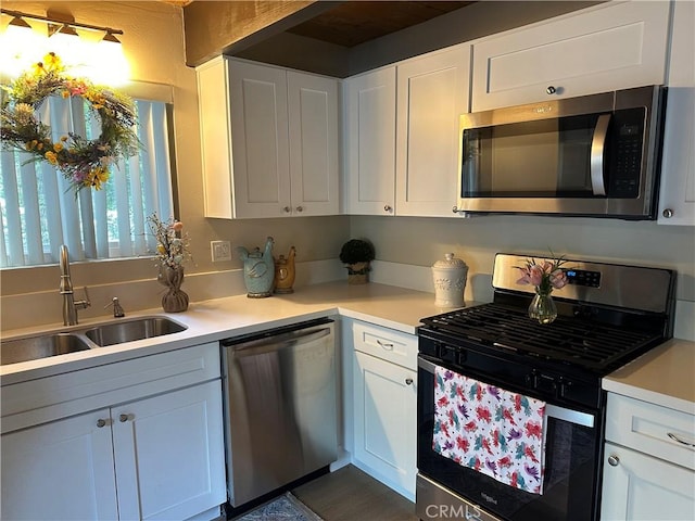 kitchen featuring stainless steel appliances, sink, and white cabinets