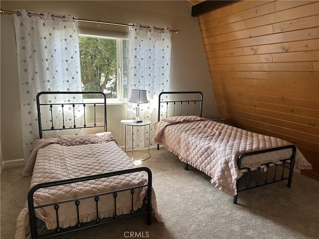 carpeted bedroom featuring wood walls