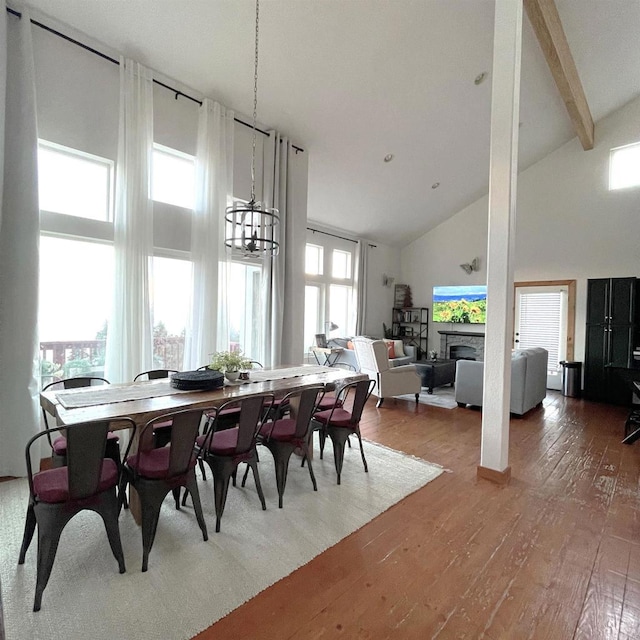 dining room featuring hardwood / wood-style floors, high vaulted ceiling, and beamed ceiling