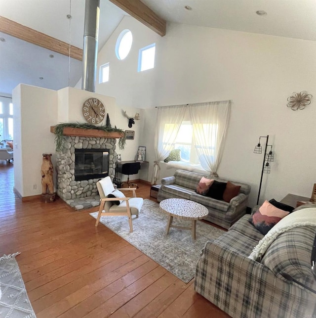 living room with beamed ceiling, a healthy amount of sunlight, wood-type flooring, and a fireplace