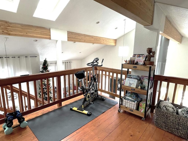 workout room featuring hardwood / wood-style flooring and lofted ceiling with skylight