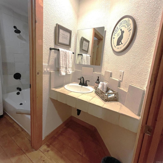 bathroom with sink, wood-type flooring, and shower / washtub combination