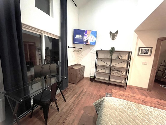 interior space with a towering ceiling and wood-type flooring