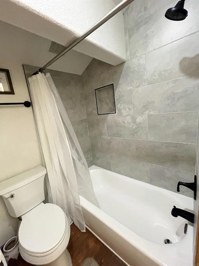 bathroom featuring shower / tub combo, hardwood / wood-style floors, and toilet