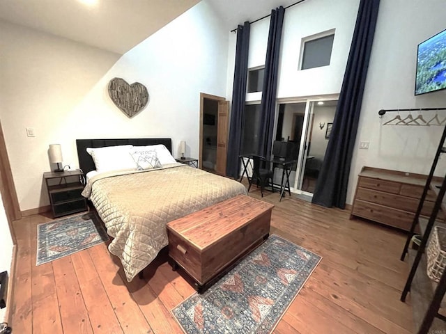 bedroom featuring hardwood / wood-style floors and high vaulted ceiling