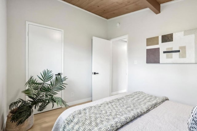 bedroom featuring beam ceiling, wood ceiling, and wood-type flooring