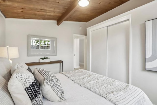 bedroom featuring wood ceiling, lofted ceiling with beams, and a closet