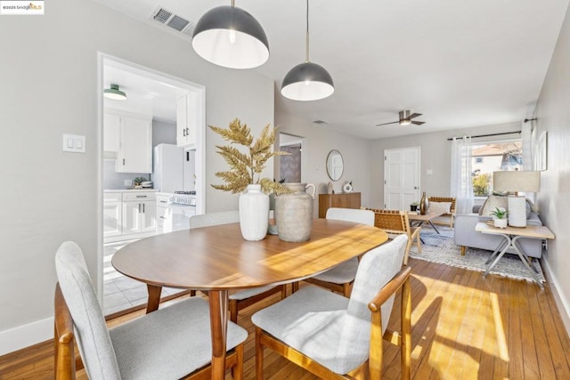 dining area with light hardwood / wood-style floors and ceiling fan