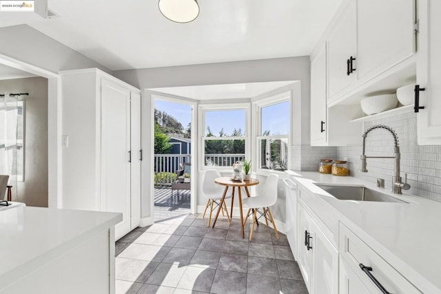 kitchen featuring white cabinetry, sink, and decorative backsplash