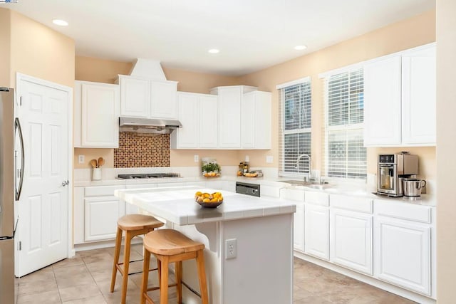 kitchen with a kitchen island, sink, white cabinets, and appliances with stainless steel finishes