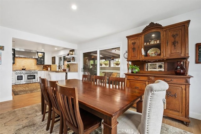 dining space featuring sink and light wood-type flooring