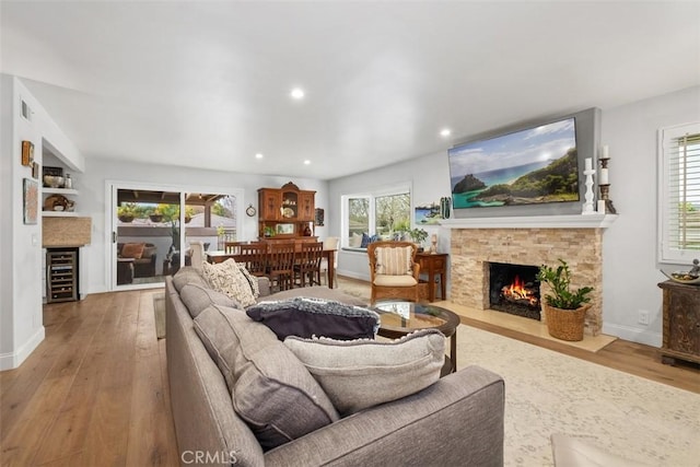 living room featuring wine cooler, a healthy amount of sunlight, and hardwood / wood-style flooring