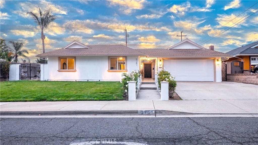 single story home with a garage and a lawn