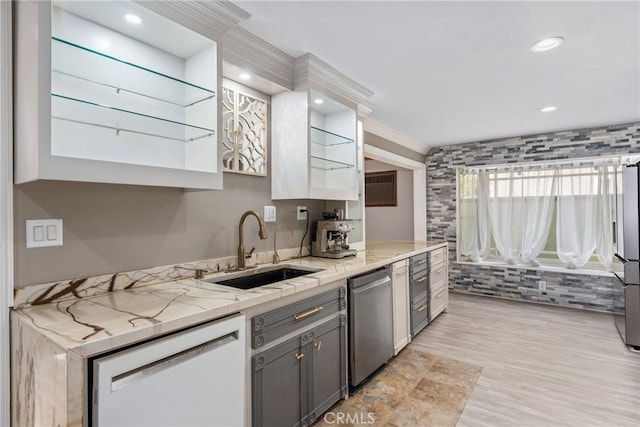 kitchen with a sink, ornamental molding, appliances with stainless steel finishes, light wood finished floors, and gray cabinetry