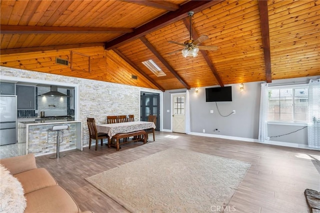 living room with a ceiling fan, wooden ceiling, wood finished floors, baseboards, and beam ceiling