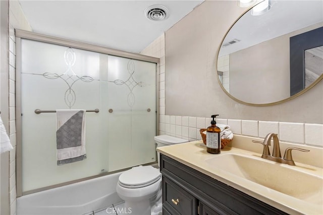 full bathroom featuring vanity, visible vents, tile walls, and toilet