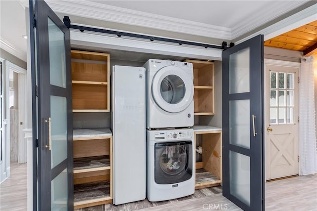 washroom featuring ornamental molding, laundry area, wood finished floors, and stacked washer / drying machine
