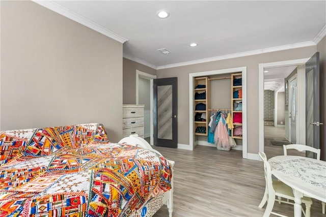 bedroom featuring crown molding, a closet, recessed lighting, wood finished floors, and baseboards