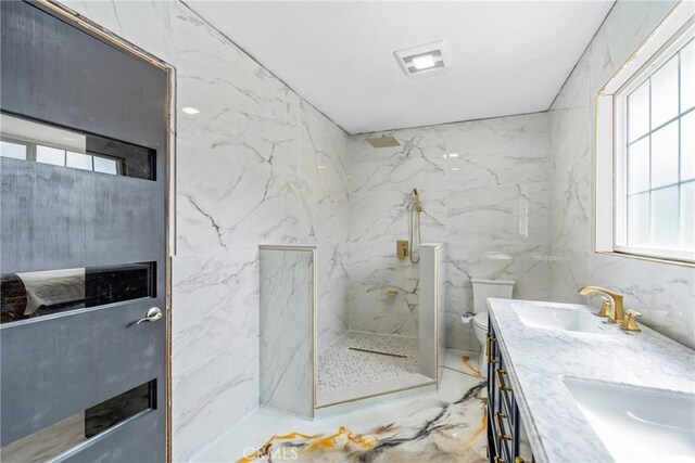 bathroom featuring double vanity, toilet, a marble finish shower, visible vents, and a sink