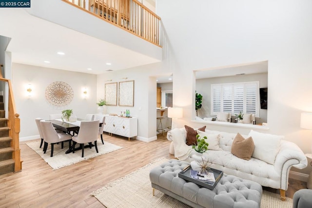 living room with a high ceiling and light wood-type flooring