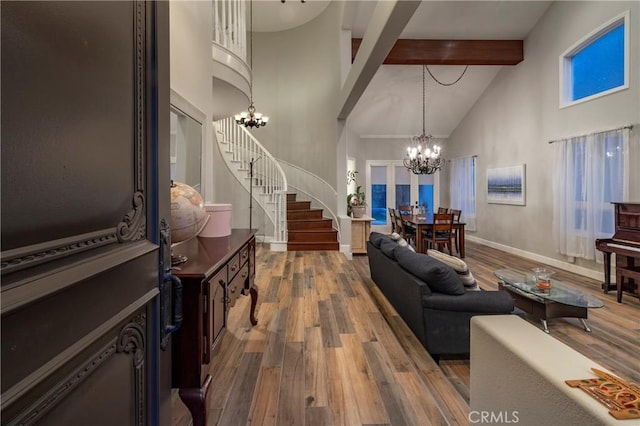 living room featuring a notable chandelier, beam ceiling, and hardwood / wood-style flooring