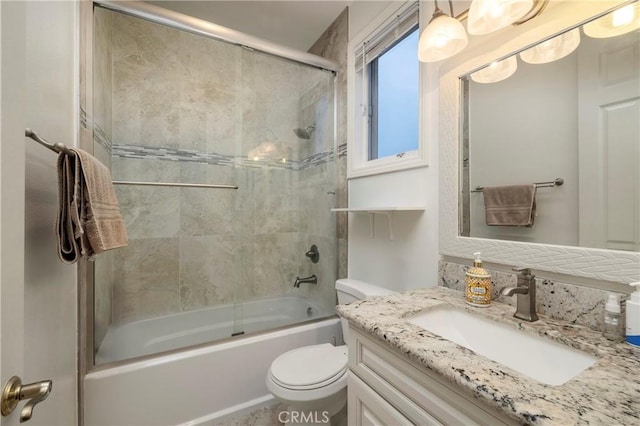 full bathroom with bath / shower combo with glass door, vanity, and toilet