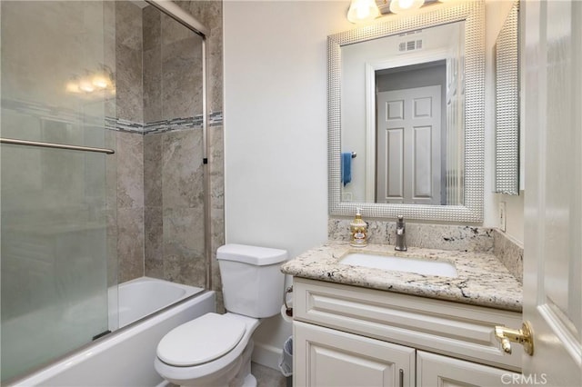 full bathroom featuring vanity, shower / bath combination with glass door, and toilet