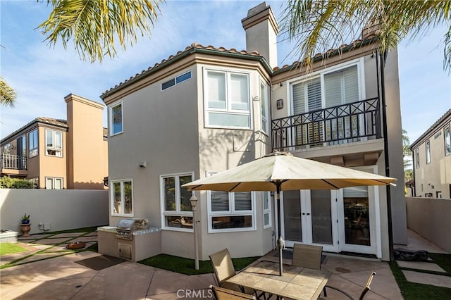 rear view of house with french doors, area for grilling, and a patio area