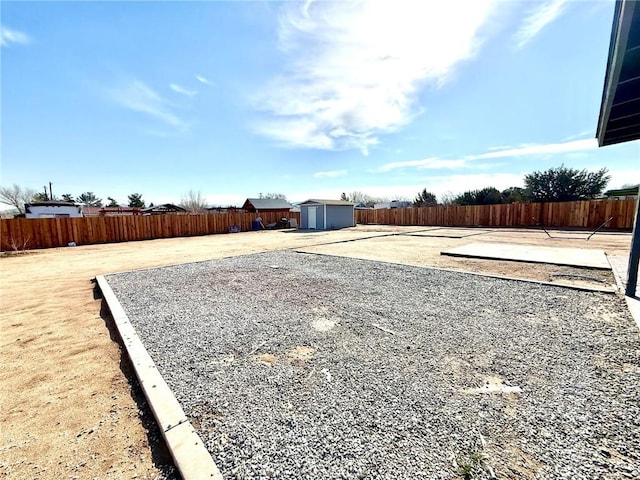 view of yard featuring an outbuilding, a patio area, a storage shed, and a fenced backyard