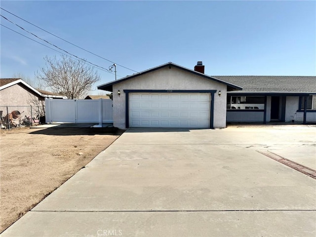 ranch-style home with fence, a garage, driveway, and stucco siding