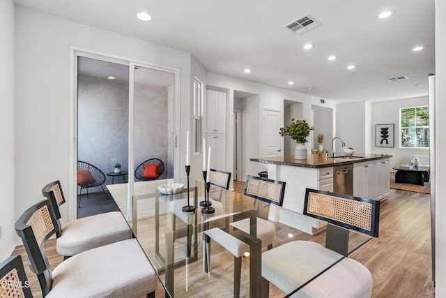 dining area featuring sink and light wood-type flooring