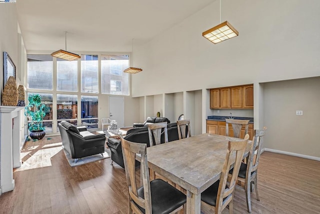 dining area featuring wood-type flooring and a high ceiling