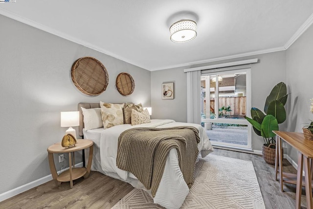 bedroom with crown molding, light hardwood / wood-style floors, and access to outside