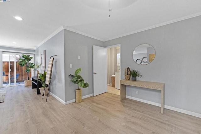 hall with ornamental molding and light hardwood / wood-style flooring