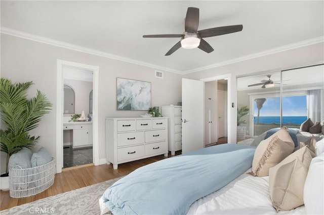 bedroom featuring hardwood / wood-style flooring, ornamental molding, access to outside, ceiling fan, and ensuite bath