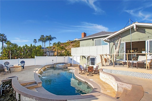 view of pool featuring an outdoor fire pit, a patio, pool water feature, and an in ground hot tub