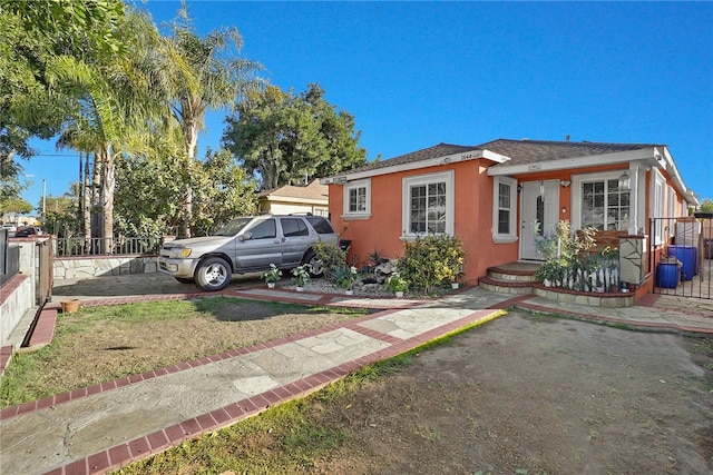 bungalow-style house with fence and stucco siding