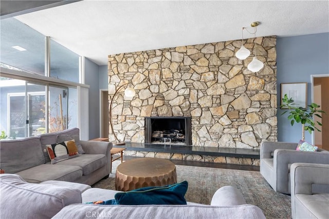 living room featuring a stone fireplace and a textured ceiling