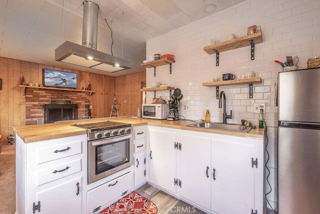 kitchen with extractor fan, stainless steel appliances, sink, and white cabinets