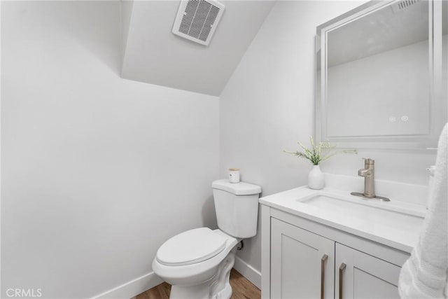 bathroom featuring vanity, toilet, and hardwood / wood-style floors