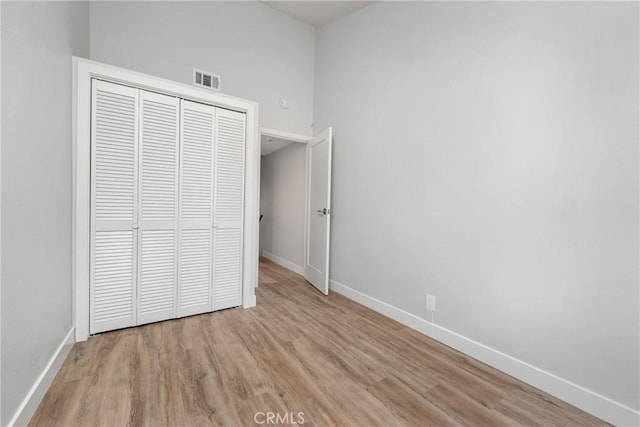 unfurnished bedroom featuring light hardwood / wood-style floors and a closet