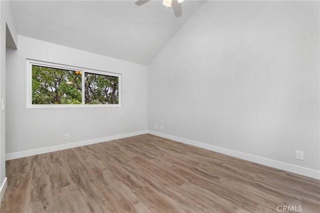 spare room featuring lofted ceiling, light hardwood / wood-style floors, and ceiling fan