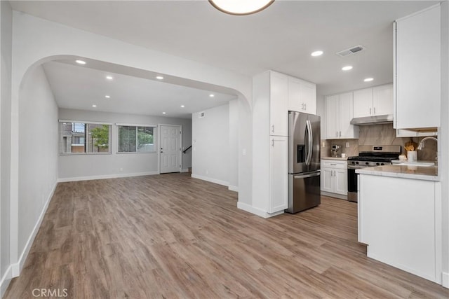 kitchen featuring backsplash, sink, white cabinets, and appliances with stainless steel finishes