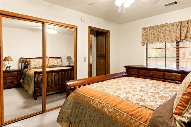 carpeted bedroom featuring ceiling fan and a closet