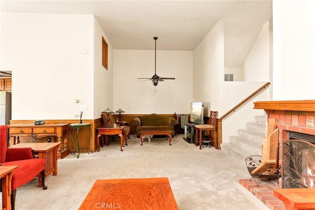 carpeted living room featuring ceiling fan and a brick fireplace