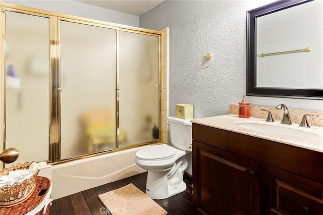 full bathroom featuring enclosed tub / shower combo, wood-type flooring, vanity, and toilet