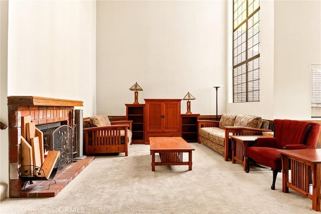 interior space featuring a high ceiling, light carpet, and a fireplace