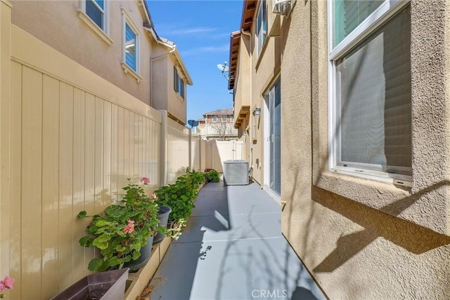 view of property exterior with a patio, central air condition unit, fence, and stucco siding